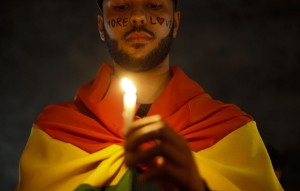 TOPSHOT - Activists carrying lit candles and flags participate in a vigil to pay tribute to the victims of the massacre occured at a gay club in Orlando, in Sao Paulo, Brazil, on June 15, 2016.  / AFP / Miguel Schincariol        (Photo credit should read MIGUEL SCHINCARIOL/AFP/Getty Images)